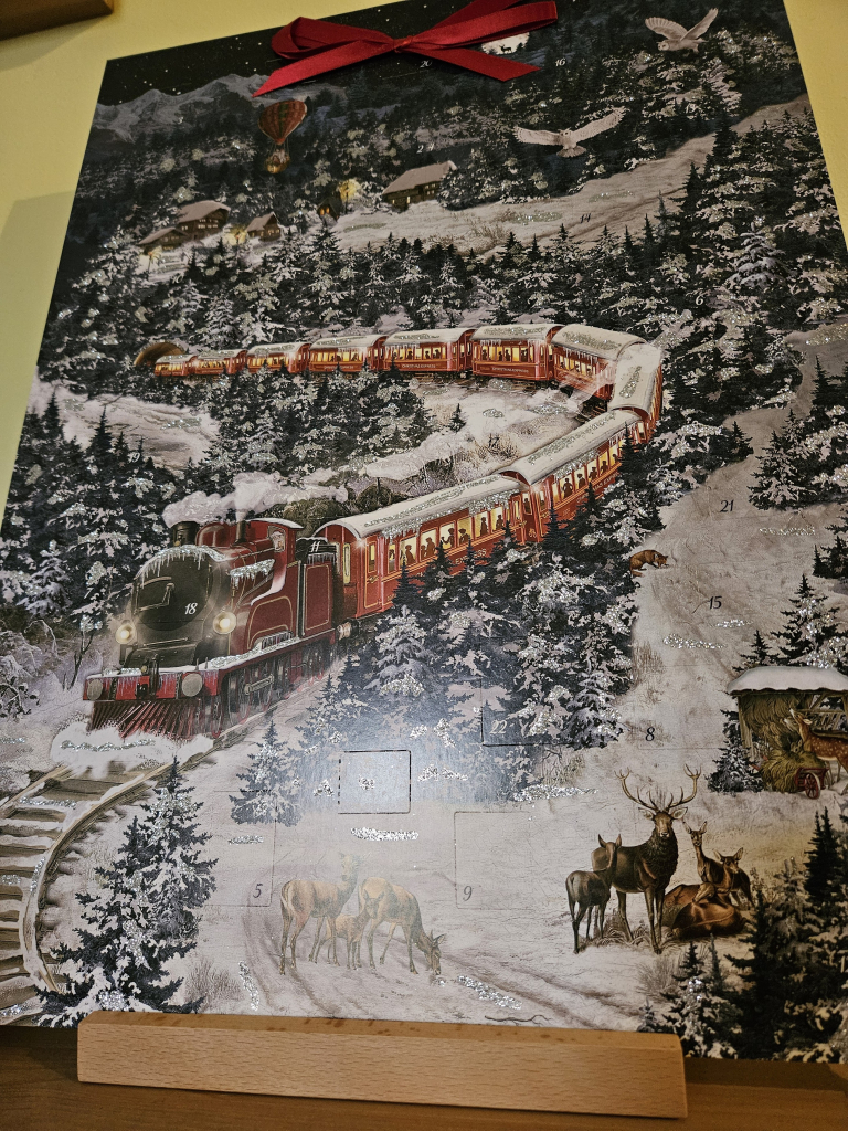 An advent calendar featuring a steam train and snow scene