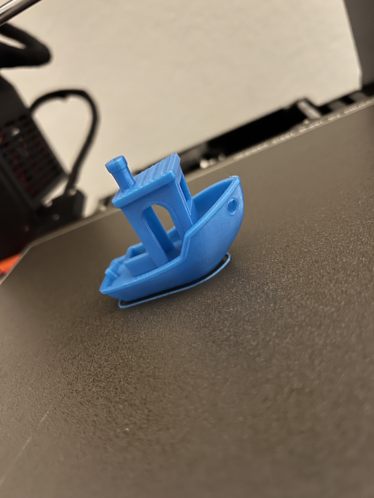 Closeup of a 3D-Benchy boat model sitting on a 3D printer build plate