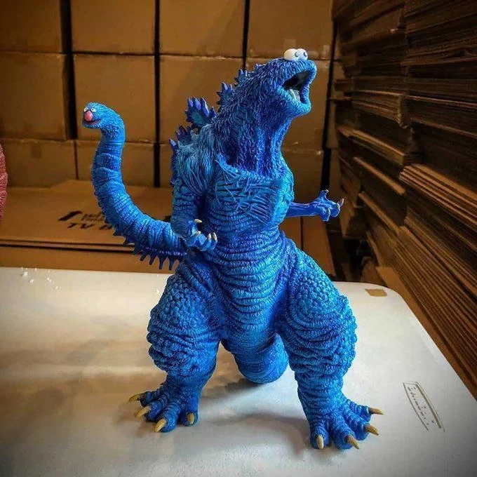 model of a kaiju-like monster that is blue, that looks like the cookie monster from Sesame Street -- it's tail has Grover's head at the end of it.