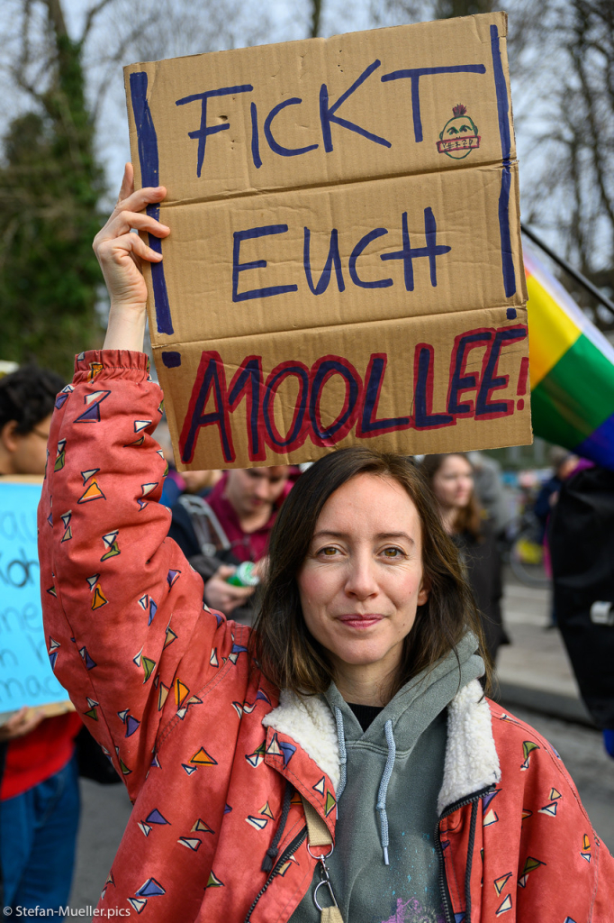 Aktivistin bei der Blockade der Elsenbrücke (Ende der A100) durch verschiedene Klimagruppen. Auf dem Plakat steht: „Fickt Euch A100llee!“, Berlin, 02.03.2024