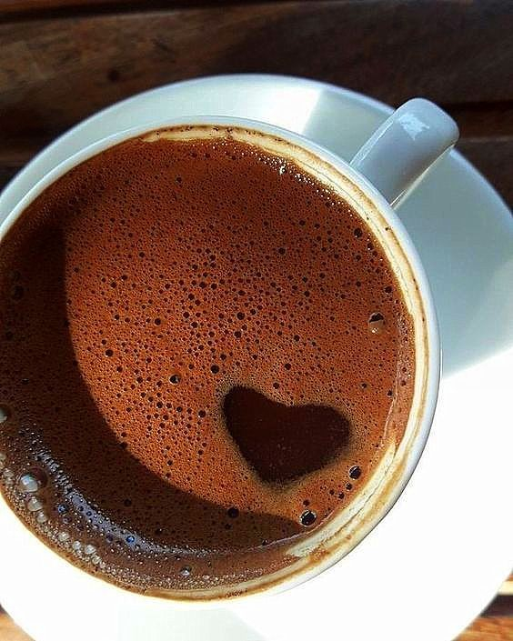 cup of coffee seen from above, with the shape of a heart in the foam