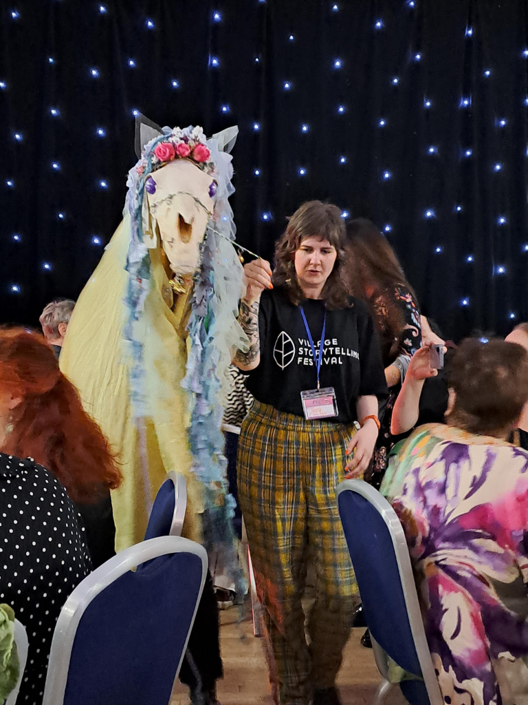 A Mari Lwyd (a horse skull decorated with flowers and ribbons, carried as a puppet by a person covered with a cloak) walked by one of the event organizers on a leash with bells through the dining room, to the great surprise of attending guests.