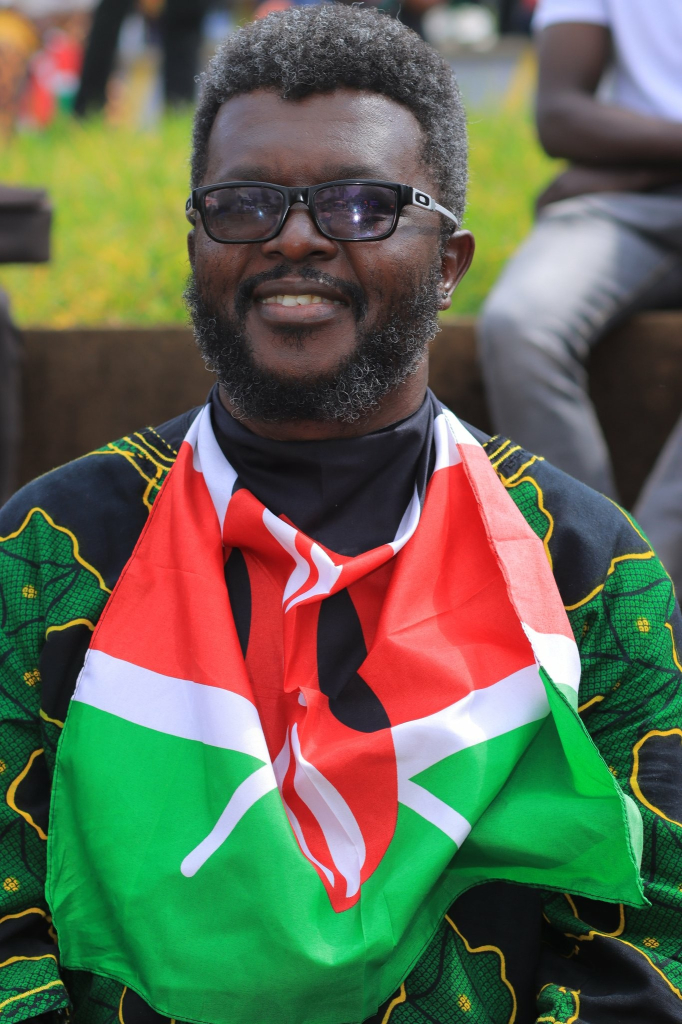 Kenyan with a flag while smiling during concerts to commemorate victims of police brutality 