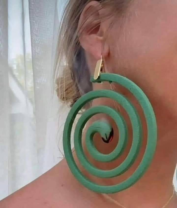 person using a lit mosquito coil as an earing