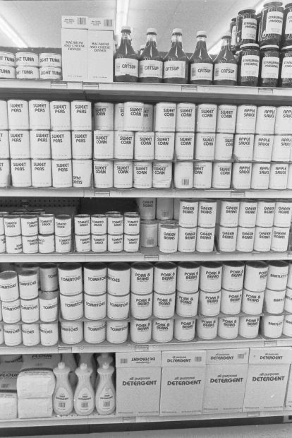 A photo of a generic foods aisle in the Seventies, with all the products having white labels with black printing of what is in the can.