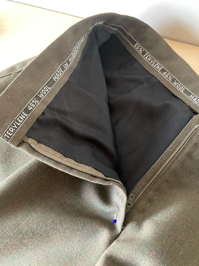 Photo of the inside waistband of the shorts: featuring the woven selvedge edge of the fabric as edge-finish. Also visible: black acetate lining.