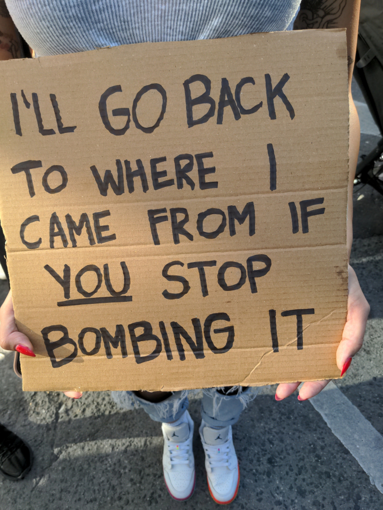 Protest sign in Toronto "I'll Go Back to Where I Came From If You Stop Bombing It.