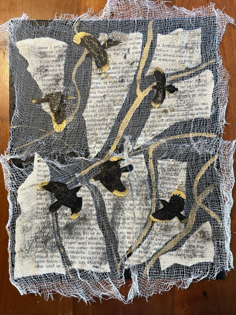 Rectangle painted in matte black with a ripped up page from an Icelandic book. In between the paper pieces are painted gold streaks, possibly resembling rivers or evoking kintsugi. There is cheesecloth glued on top and rust powder has been sprinkled, although ti didn't turn very rusty and looks more like mold on book pages. There are six crow sillhouettes flying over the pieces of page. they have gold tipped wings and tails and asemic writing in gold on their black backs. 