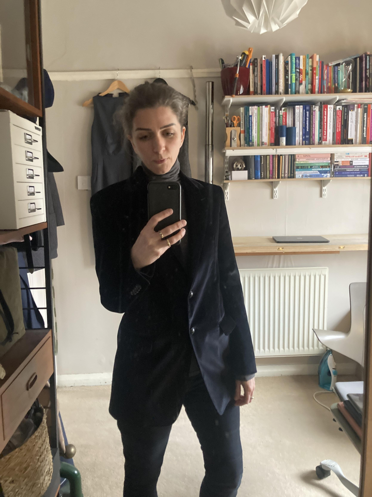 Me photographing myself in the mirror, wearing a (very beautiful) black velvet blazer, a dark-grey polo-neck top, black jeans, and a demeanour of unutterable fatigue.