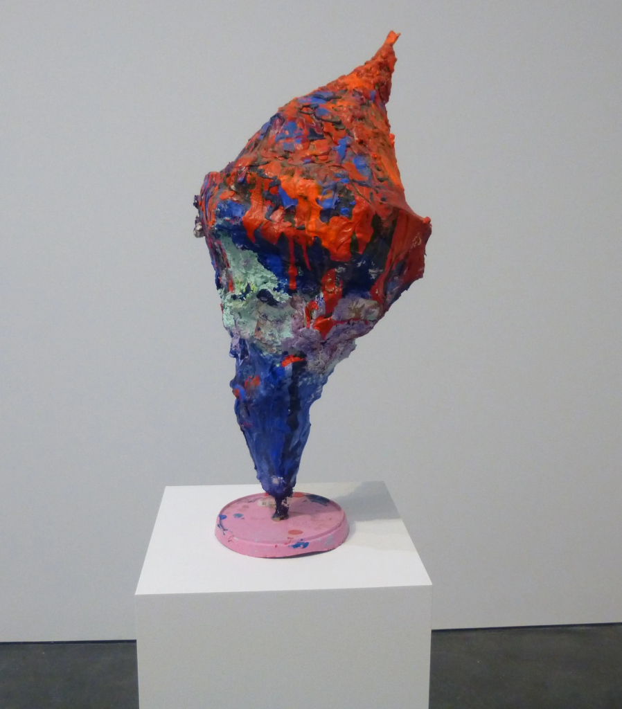 Abstract, textured sculpture with drippy orange and blue colors