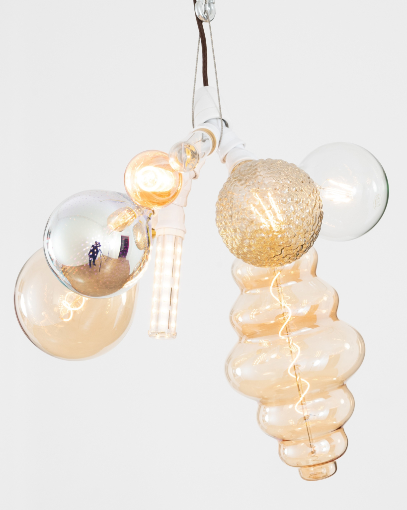 Hanging sculpture composed of many different types of lightbulbs in clusters