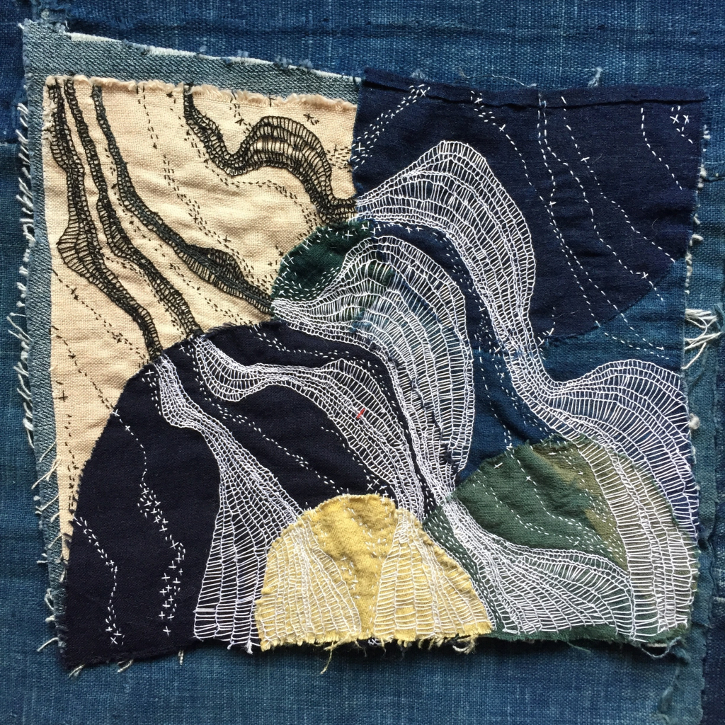 Abstract embroidery with swirling white and black threads over blue and cream patches