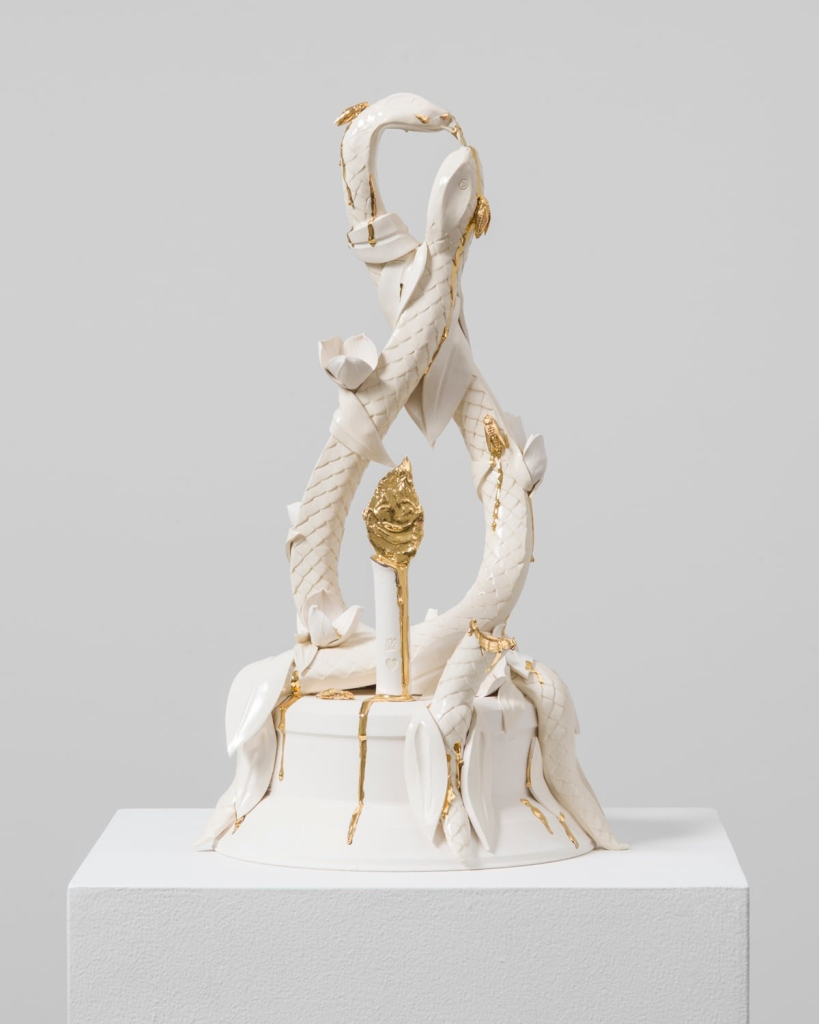 Ceramic sculpture of two slender snakes twirling around each other, in white and gold