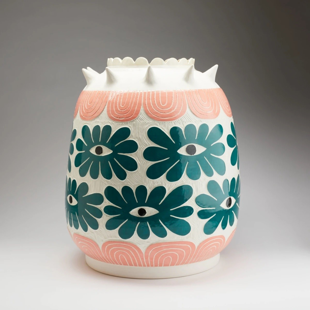 Large white pot with floral eye designs in turquoise and a pink patterned border