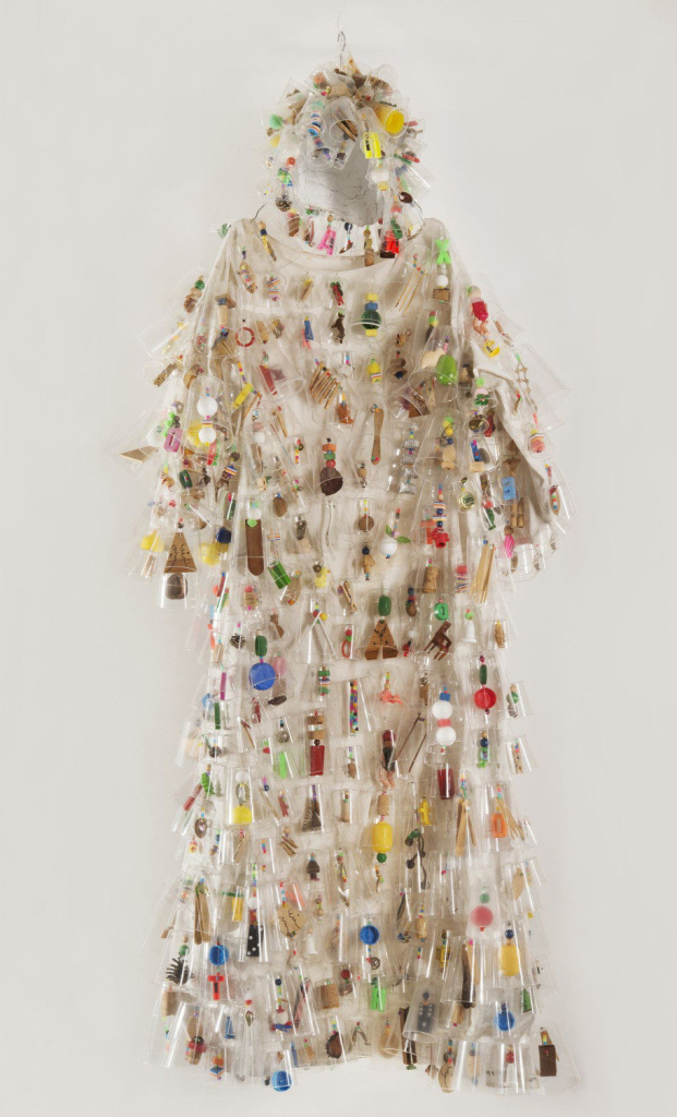 Full body sound suit in white fabric covered with dangling objects wrapped in plastic