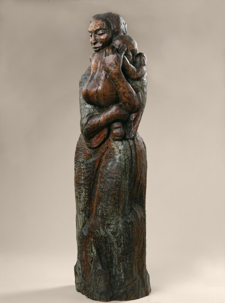 Carved wooden sculpture of a standing woman holding a child in her arms