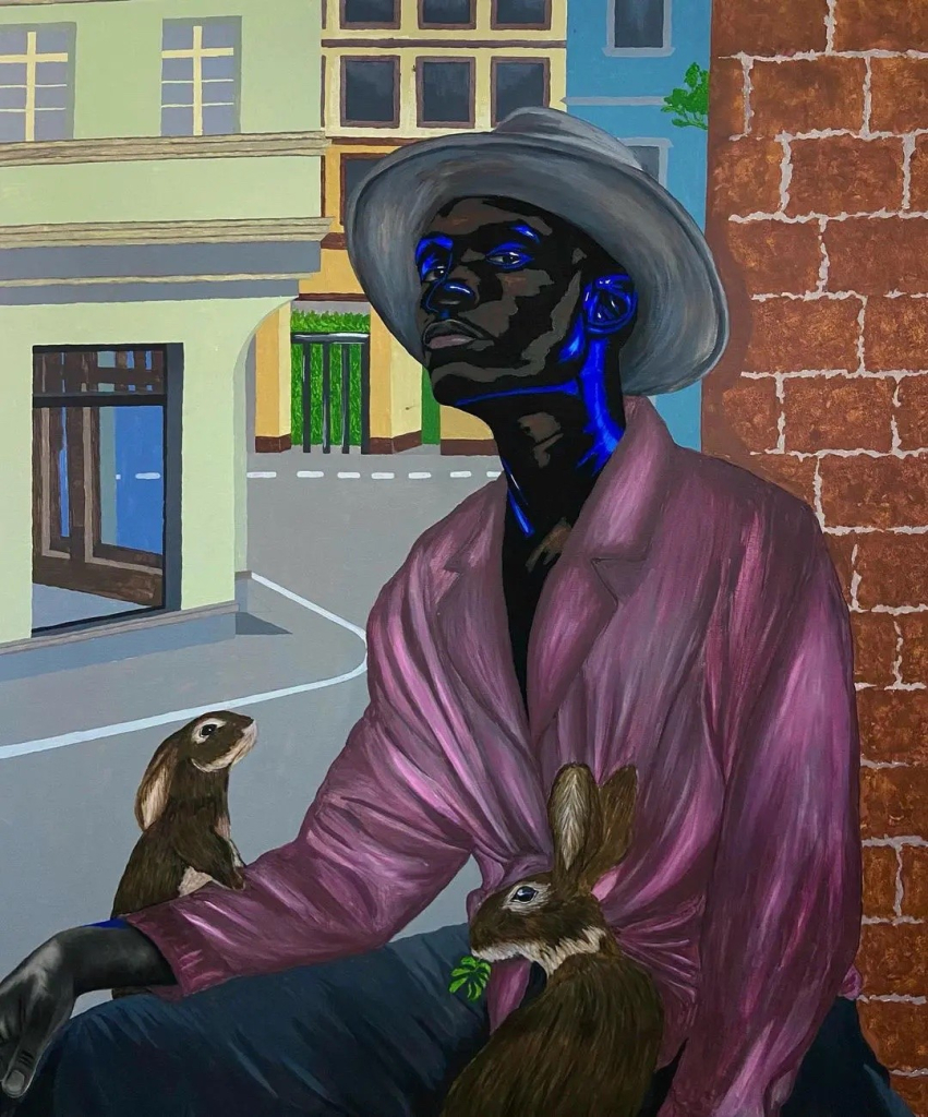 Painting of a young Black man wearing a pink shirt and grey hat, sitting outside against a brick wall with two rabbits at his lap and an empty commercial street behind him