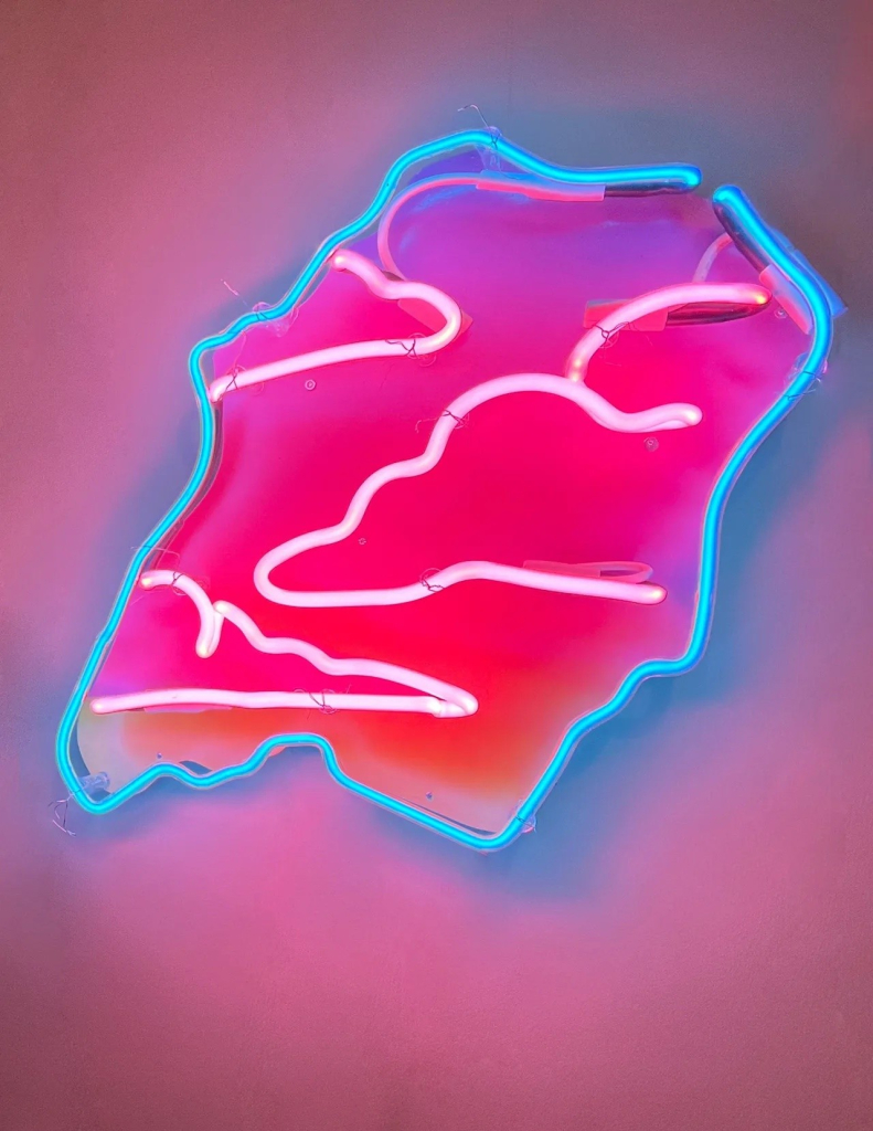 Neon wall sculpture of a jagged cut-out shape with a blue border and soft pink clouds within