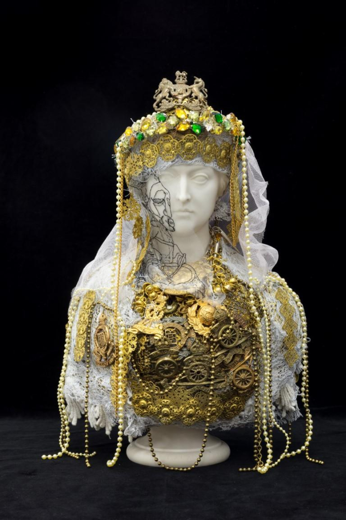 Marble sculpture of Queen Victoria draped with gold jewelry and military imagery