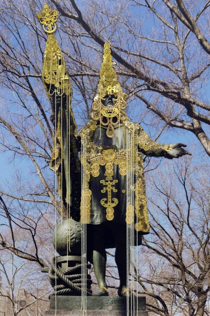 Photo of an outdoor sculpture of Columbus covered in gold and pearls