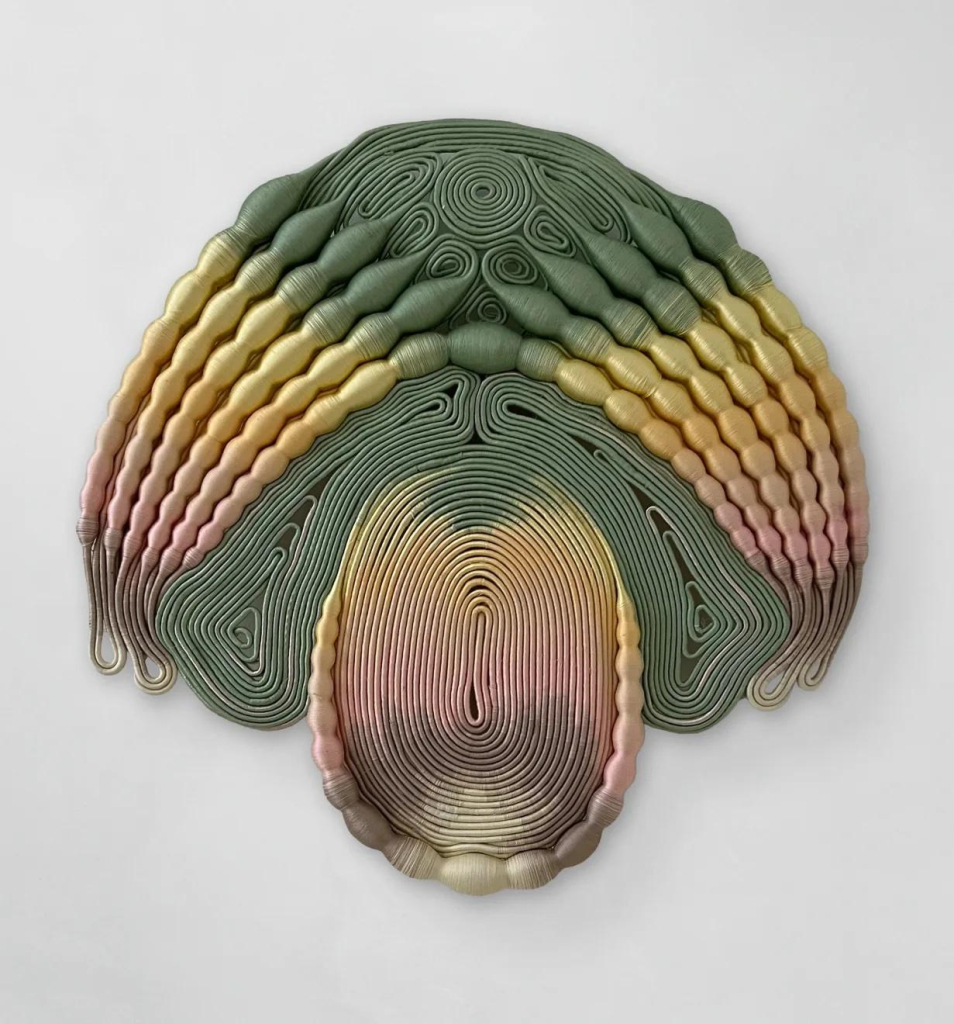 Symmetrical abstraction in green, yellow, and soft pink made up of layers of textile lines and bulbous forms