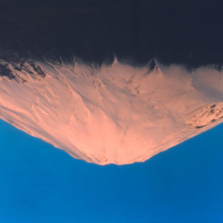 Slightly blurry image of Mt Fuji shown upside down against a deep blue sky