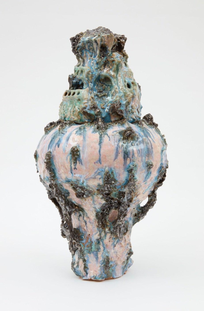 Ceramic vessel with a narrow base expanding up into a rounded ball, with a melting architectural form on top, with pale pink and green glazes