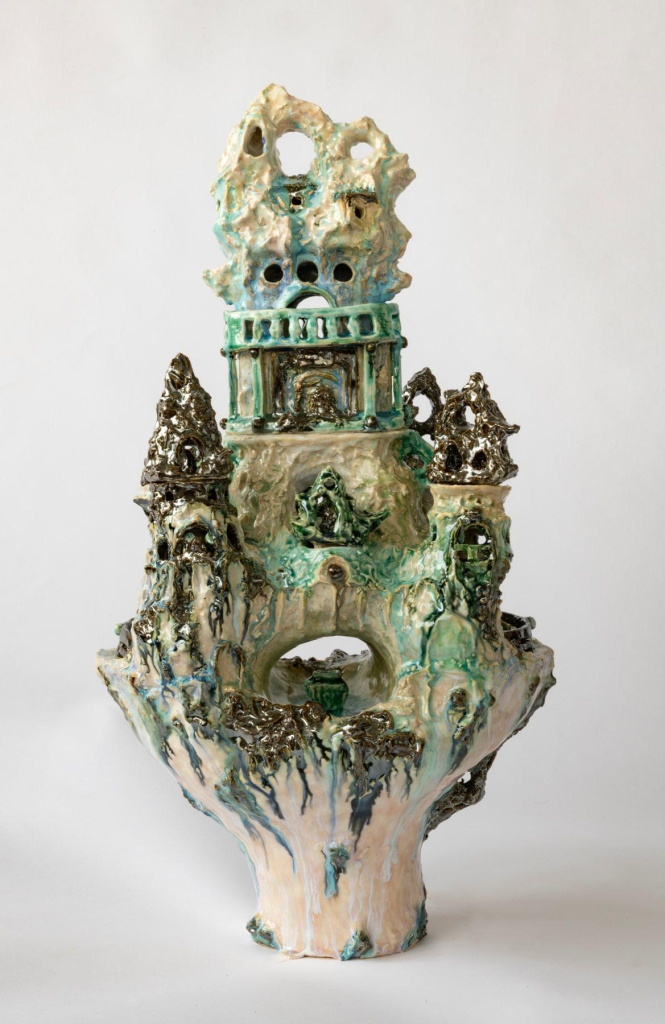 Standing ceramic form with architectural motifs and soft green, pink, and light brown glazes