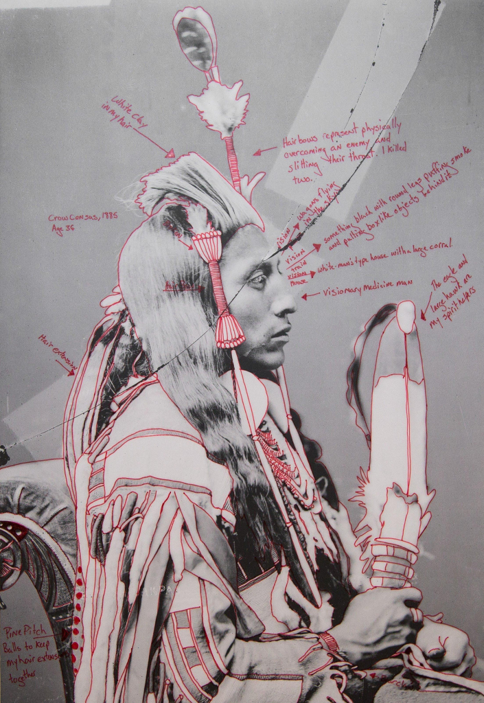 Black and white photo portrait of a Crow chief, with notes in red pen added identifying different aspects of his clothing and additional symbols, along with some hypothetical observations