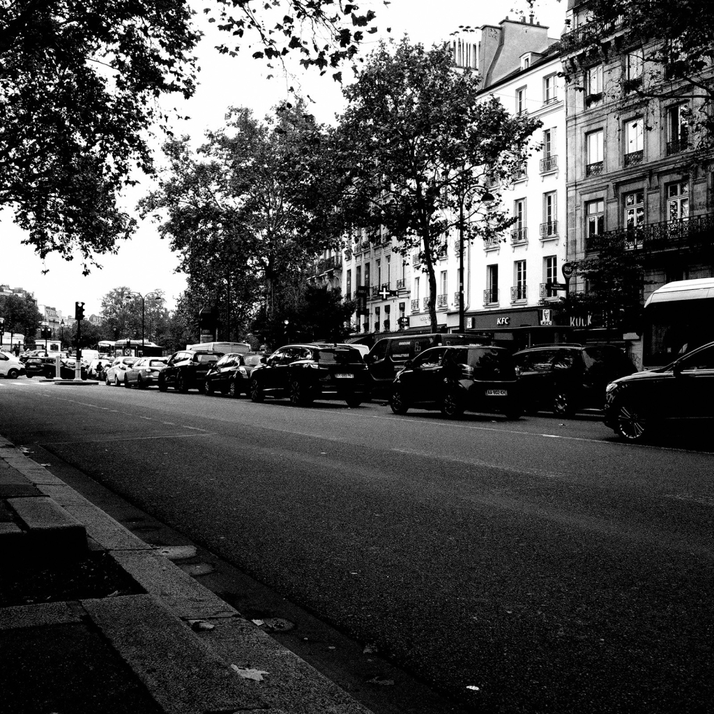 Photo d'un bouchon automobile dans une rue parisienne. La moitié de la chaussée est occupée par des dizaines de voitures arrêtées.