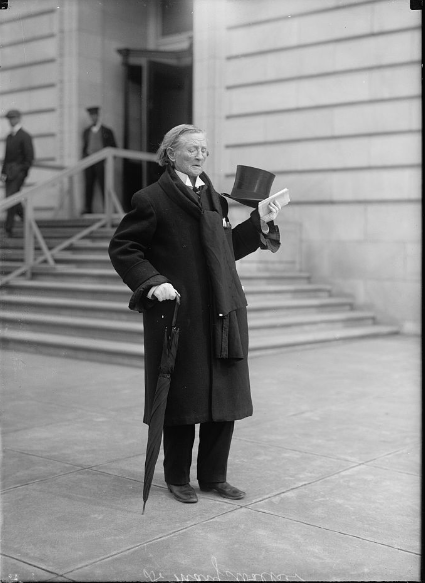 Dr Mary Edwards Walker in later life. She is a white woman with white hair wearing trousers, a frock coat and a topper. She still has the medal on the breast of her coat.