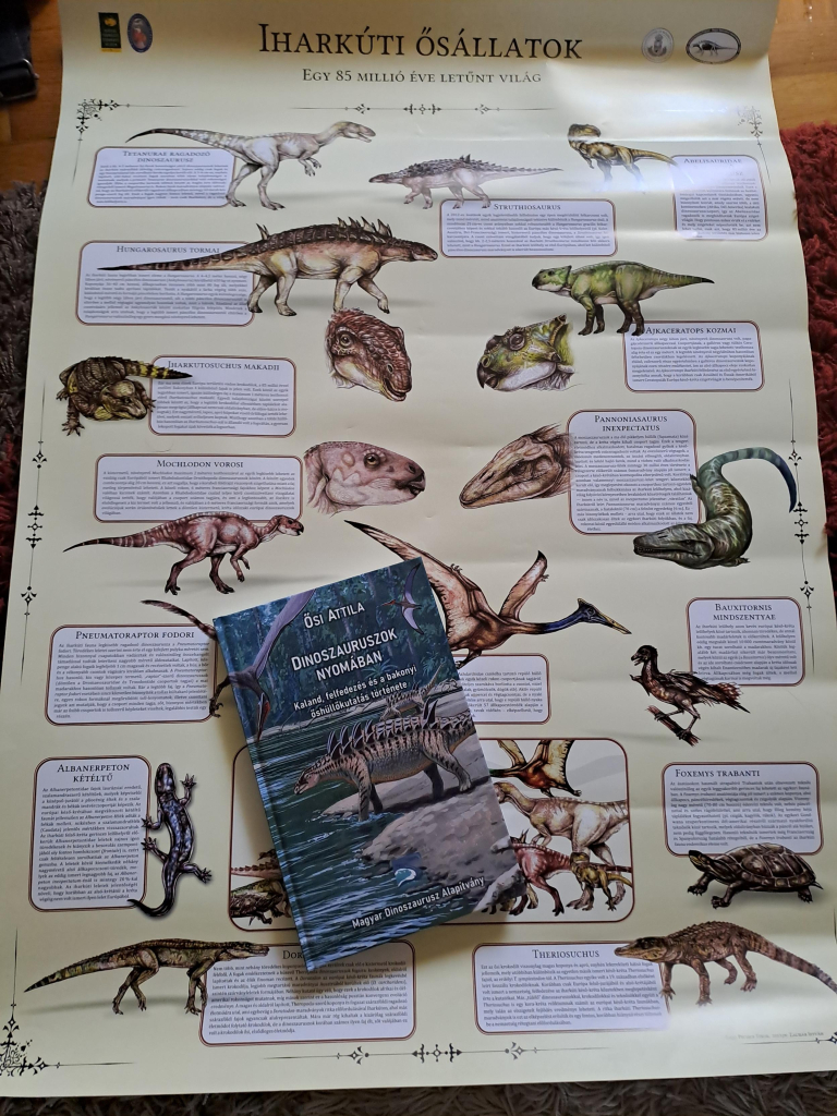 A colorful poster featuring art depicting several dinosaurs and other Cretaceaus creatures accompanied by written descriptions, as well as a book with a cover that features more paleo art. 