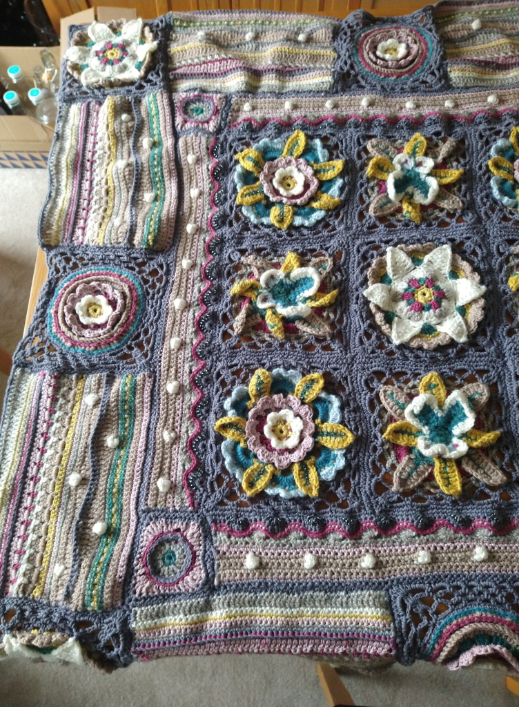 Close up view of a Crochet Afghan in shades of grey and pink showing bobble and bead detail 