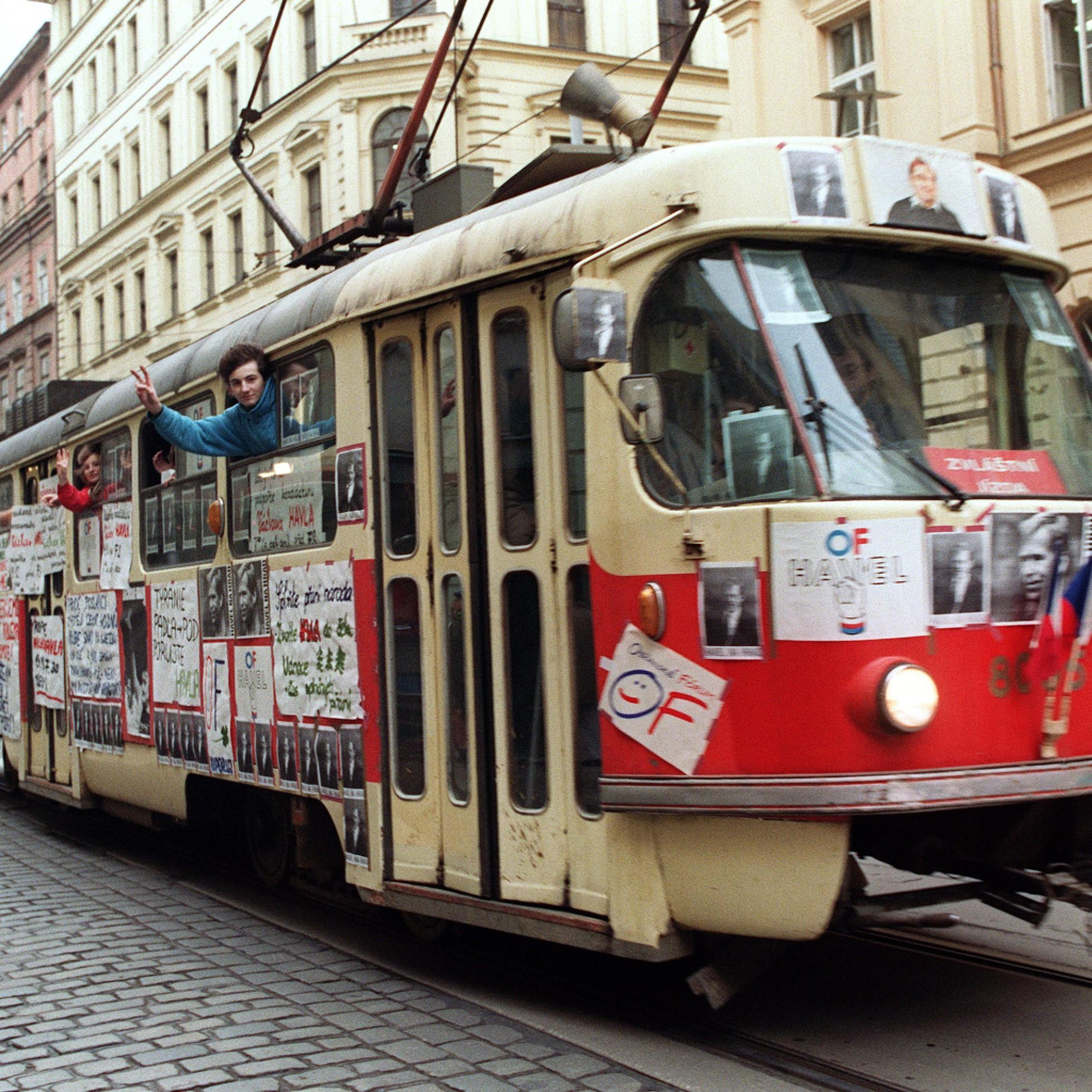 Young people waving from a tramway in support of Vaclav Havel's presidency during the protest rally on 17 December 1989 near Wenceslas Square in Prague. They are leaning out the window and making the victory sign with their hands. 