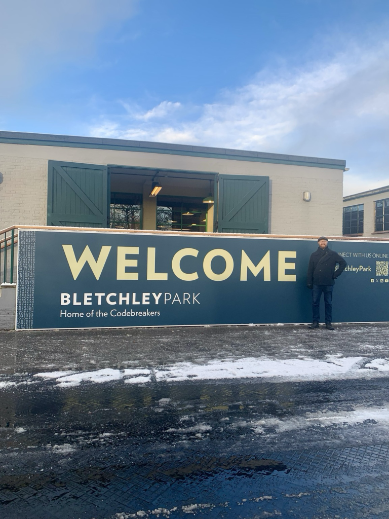 Ben in front of the “Welcome Bletchley Park Home of the Codebreakers” sign