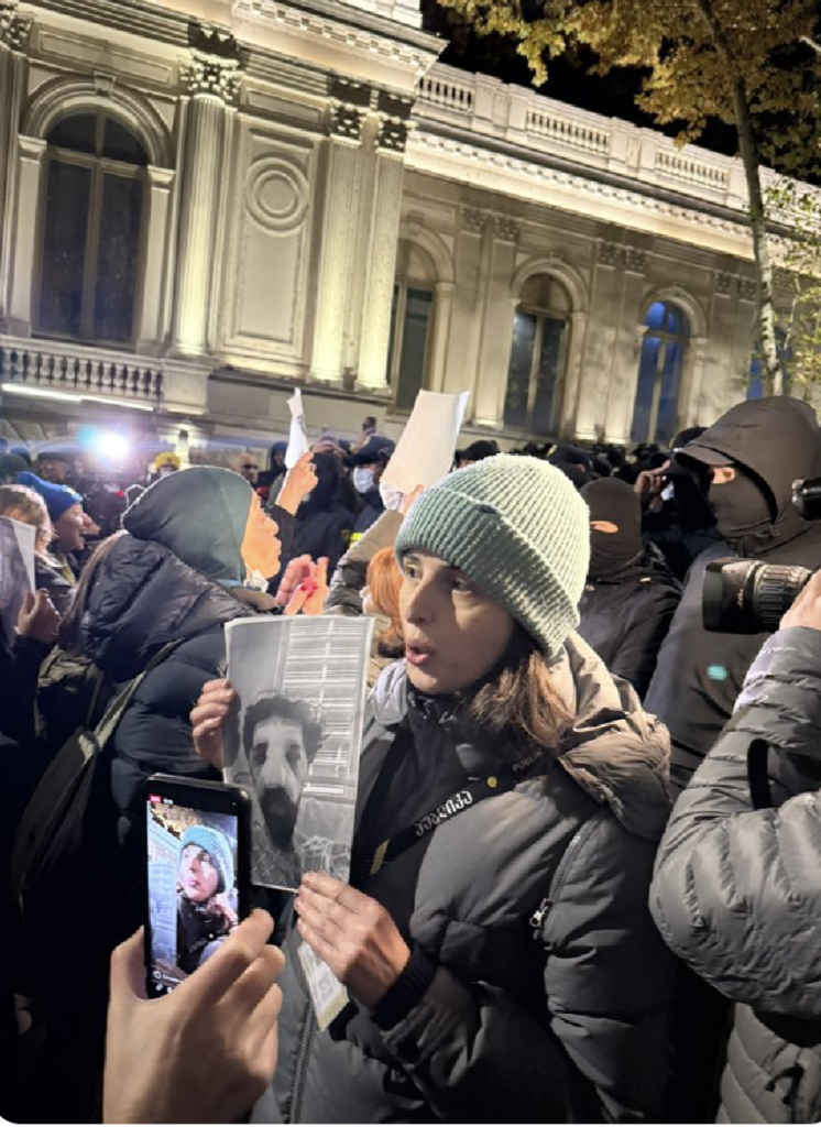 A journalist in Tbilisi, Georgia holding a photograph of an injured colleague.