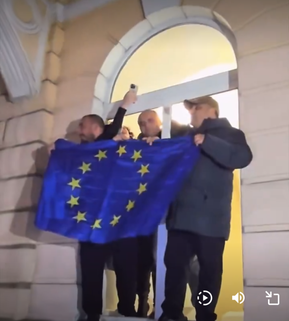 Protestors waving an EU flag from a window in city hall, Batumi, Georgia.