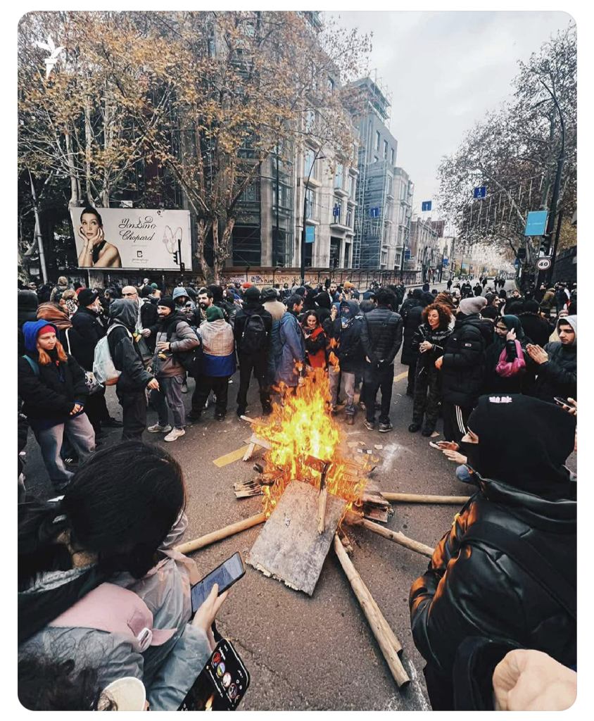 Protestors stand round a makeshift camp fire in Tbilisi,Georgia.