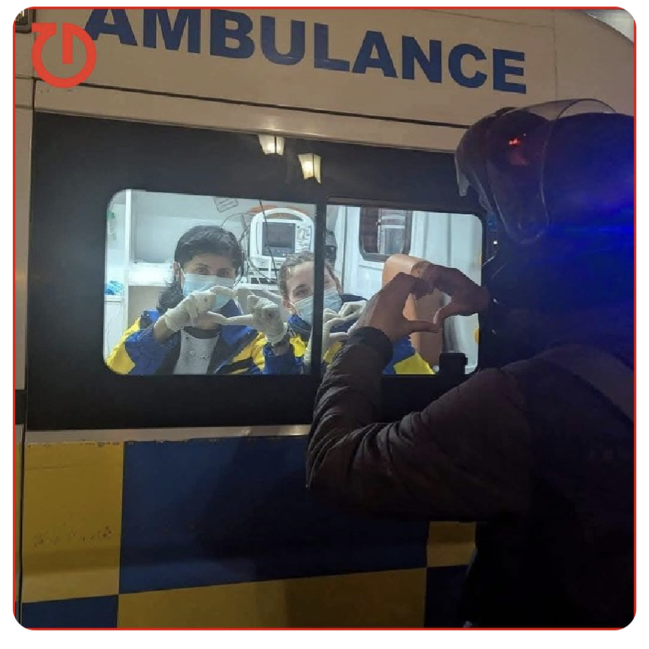 Medics make heart signs from the window of an ambulance as protestors outside make heart signs back to them in Tbilisi, Georgia