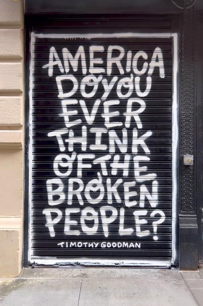 Streetart. A text in capital letters has been painted in white paint on a black roll-up door at a store in Greenwich Village. The text reads: "America do you ever think of the broken people?"
Info: Timothy Goodman is an award-winning American artist, graphic designer, street artist, author and speaker.