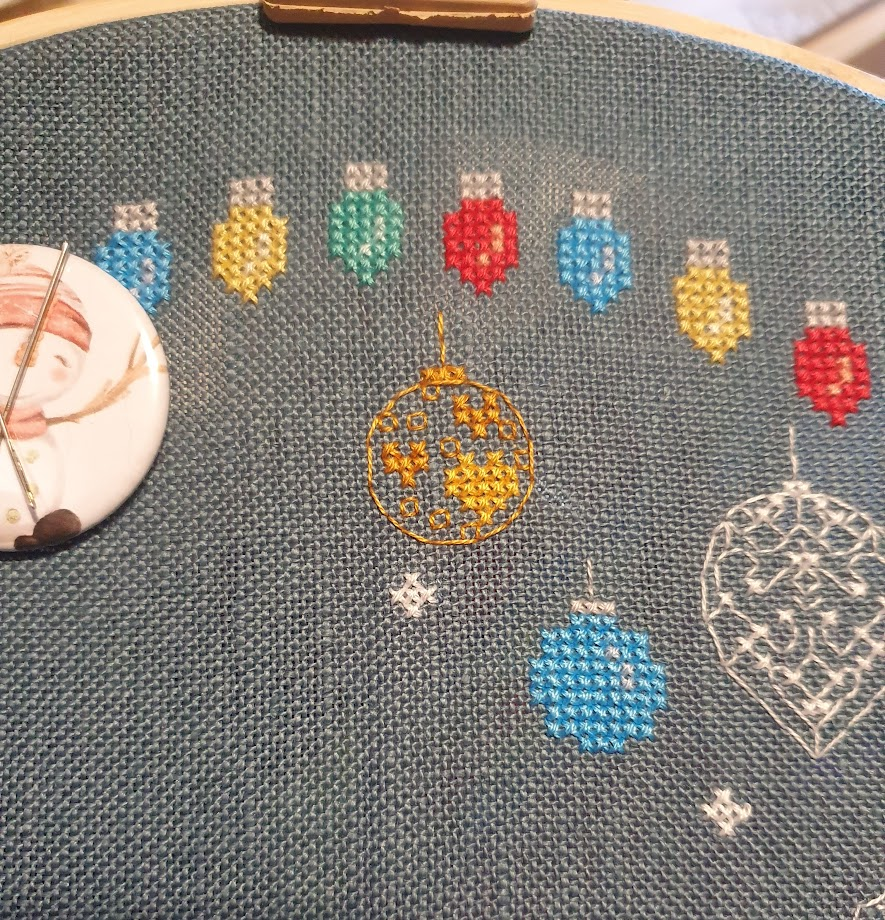 The same cross stitch, the bauble this time is a gold round bauble near the top of the pattern, the bauble is done in gold backstitch with little gold and yellow hearts in the middle. 