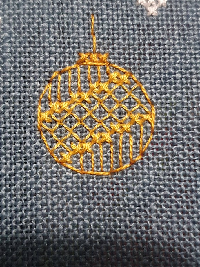 The cross stitch continues. This time its a little gold bauble. A shade called Old Gold makes up the external circle and lines of the decoration, the "inside" of the bauble is called Hops Yellow and is two diagonal lines of cross stitch with a backstitched grid between the lines. 