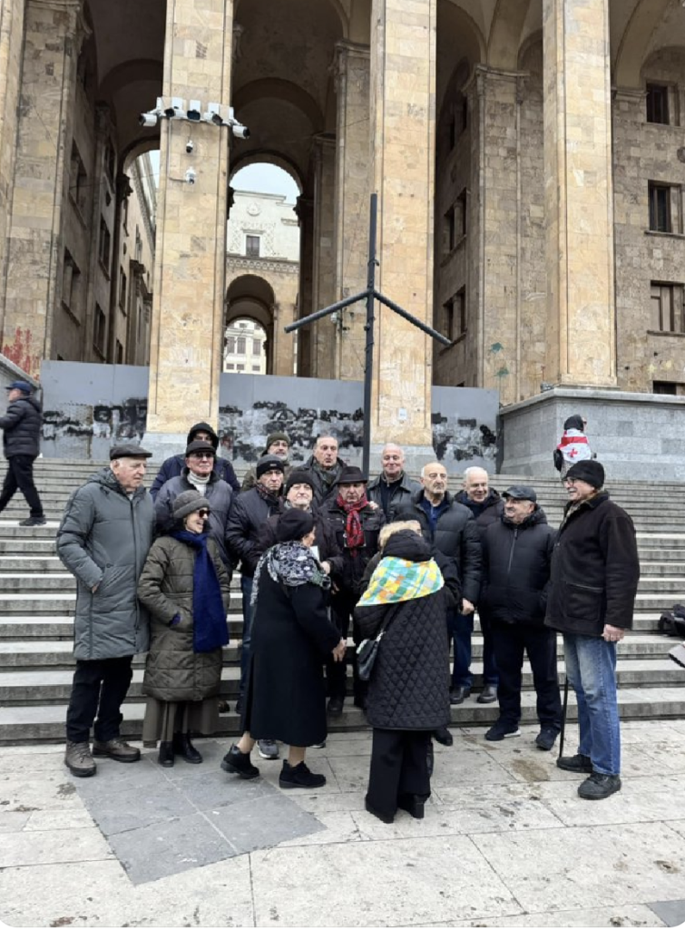 A gathering of older people on the steps of parliament Tbilisi Georgia.