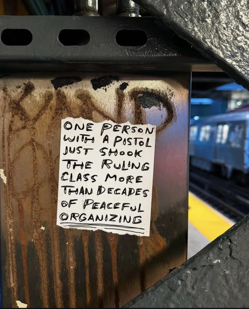 A flyer posted on a wall saying “ONE PERSON NITRO A PISTOL JUST SHOOK THE PULNG CLASS MORE THAN DECADES OF PEACEFUL ORGANIZING.”