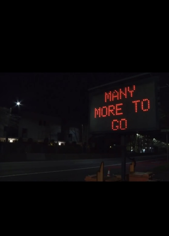 A highway sign showing the words “MANY MORE TO GO”, near Dexter Avenue, Seattle 