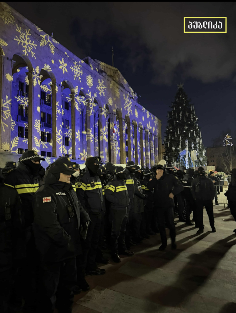 Rows of police guard the Christmas tree outside parliament in Tbilisi, Georgia. Parliament is lit up in festive colours and the tree is ready to be lit up.