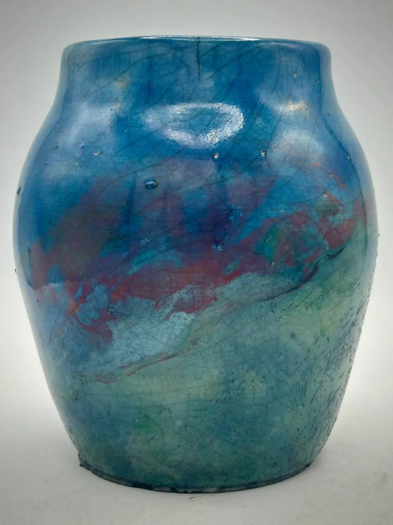 A blue/turquoise raku pottery vase with some pink, called 'Sedna' s Whisper'.