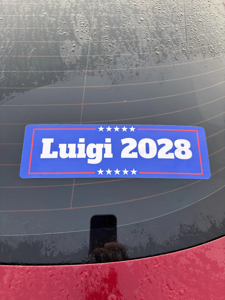 Photo is of a bumper sticking in a car window that reads:  "Luigi 2028" 