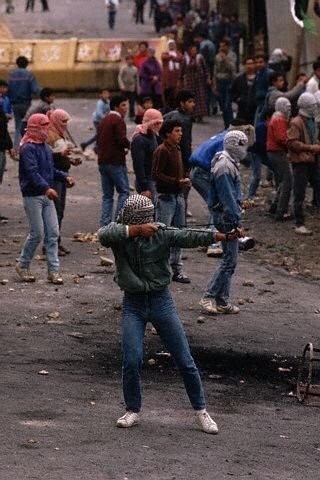 Palestinians firing slingshots