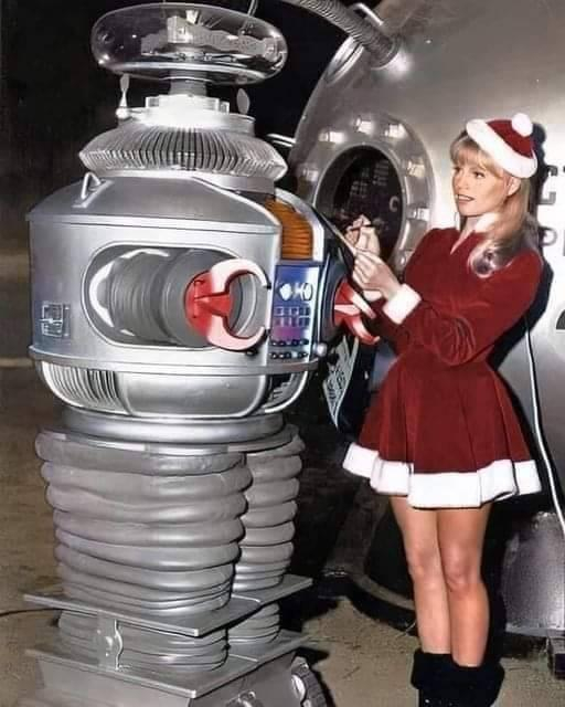 The robot from Lost in Space with Judy Robinson wearing Christmas outfit.